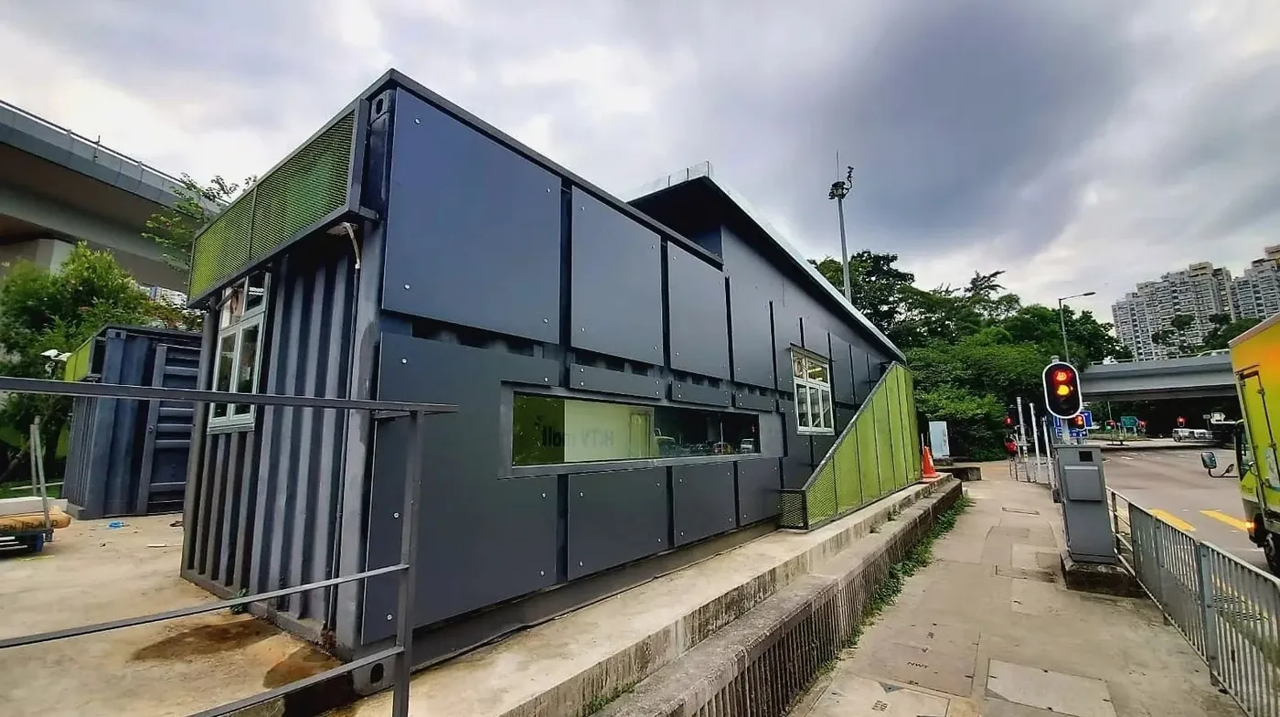 Roadside elevation of the dark container building at Sha Lek Corner